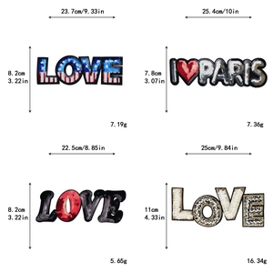 Détails de grands écussons brodés à paillettes avec des motifs LOVE stylisés