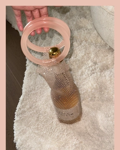 Close-up of handmade woven mesh wine bag with sparkling crystals and pink handle
