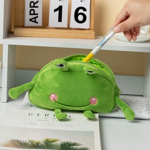 Macro shot of green plush frog pencil case with zipper closure on a desk with keyboard