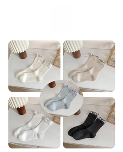 Detail of ruffled lace trim and ribbed knit texture on women's mid-calf socks