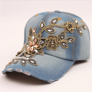 Distressed blue denim baseball cap with gold floral embroidery and sparkling rhinestones