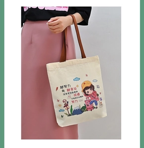 Detail of canvas tote bag with brown straps and cute girl illustration print