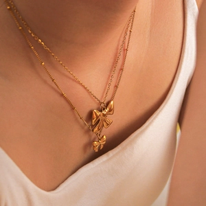 18k gold plated double layer necklace with bow pendants on a model wearing silk