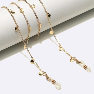 Detailed view of a gold glasses chain with delicate shell charms and silicone loops