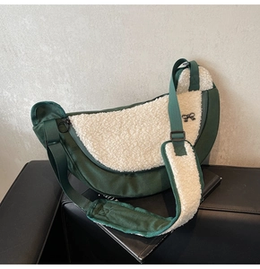 Detail of dark green fabric and cream faux fur patchwork moon bag with black bow