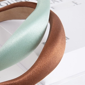 Detail of mint green and bronze satin headbands with a high-crown sponge design