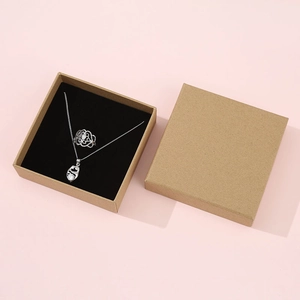 Silver necklace and ring set with hollow heart pendants in a kraft paper jewelry gift box
