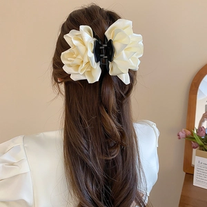 Détail d'une grande pince à cheveux rose en satin crème pour un look élégant et chic