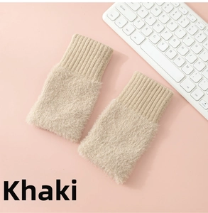 Close-up of khaki plush fingerless gloves with ribbed knit cuffs next to a white keyboard