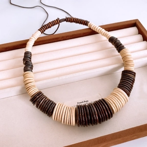 Close-up of handmade ethnic necklace with alternating cream and brown coconut shell beads