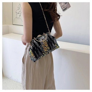 Detail of colorful sequins and gold metal handle on a stylish black party evening bag