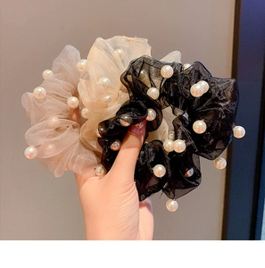 Detail of sheer organza hair scrunchies with white pearls in black and beige tones