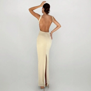 Détail d'une robe longue dos nu élégante en tissu nacré champagne avec une fente haute