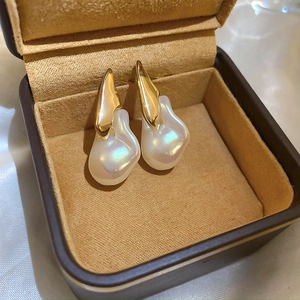 Primo piano di orecchini di perle barocche placcati in oro in scatola regalo