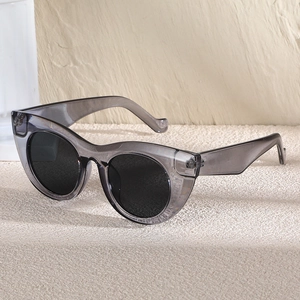 Moderne Cat-Eye-Sonnenbrille mit grauem transparentem Rahmen und schwarzen Gläsern für Damen