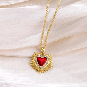 Detail shot of vintage ruby heart crown pendant with white zircons on gold plated chain