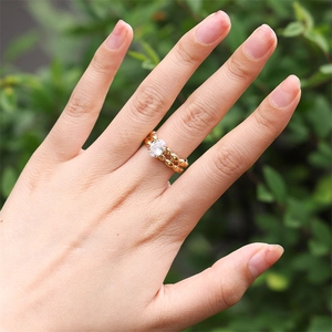 Détail d'une bague dorée texturée de perles avec un zircon cubique ovale au centre