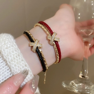 Vue détaillée de bracelets croisés plaqués or avec pierres de zircon sur poignet