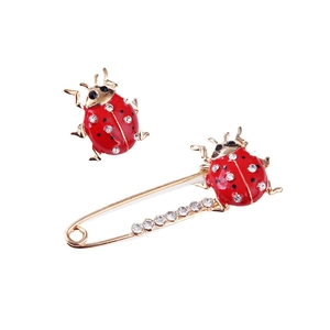 Fashionable red enamel ladybug jewelry set featuring a gold-toned brooch and stud earrings
