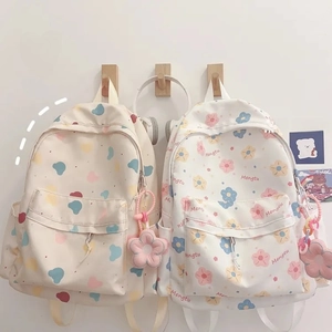 Close-up of cute cartoon bear and floral patterns on canvas backpacks with plush charms