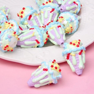 Macro shot of colorful ice cream acrylic beads with cherry details on a white dish