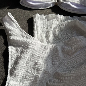 Macro shot of white smocked seersucker fabric texture for the three-piece bikini set