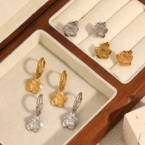 Elegant 18k gold and silver stainless steel flower earrings displayed in a wooden jewelry box