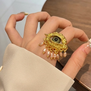 Bohemian gold Evil Eye ring with olive green stone and hanging pink pearls