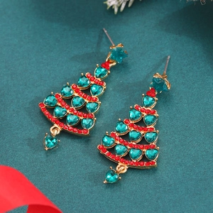 Macro shot of gold-plated Christmas tree earrings with green crystals and red rhinestones