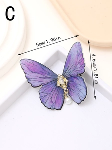 Detail view of purple butterfly hair clip with gold metal base and white pearl drop charm