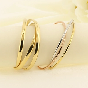 Detail of three-tone interlocking titanium steel bangles with high-polished mirror finish