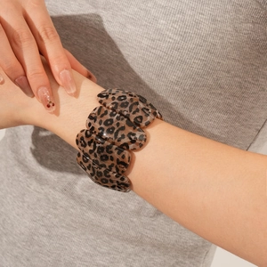 Détail d'un bracelet large en acrylique à motif léopard porté par un mannequin