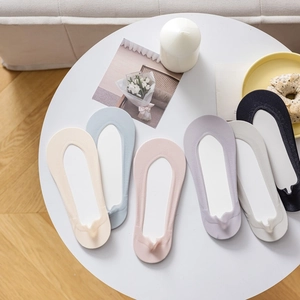 Detailed set of six low-cut invisible socks in Morandi tones on a white round table