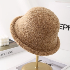 Detail of light brown plush cloche hat texture on elegant display stand with home decor