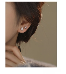 Close-up of S999 sterling silver butterfly stud earrings with sparkling zircon on ear