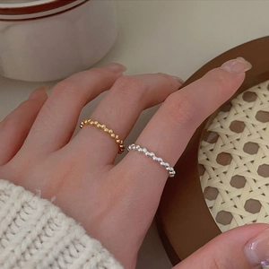 Minimalist 925 sterling silver beaded rings in gold and silver, layered on fingers