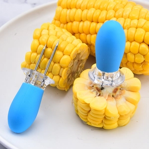 Blue handle stainless steel corn cob holders on a plate for outdoor BBQ use