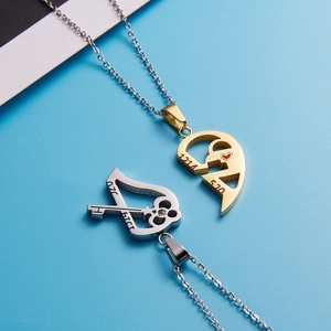 Detail view of gold heart and silver key puzzle pendants for couples on a blue surface