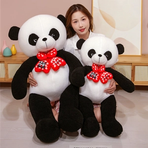 Detail view showing a large and small black and white panda plush toy with red bows