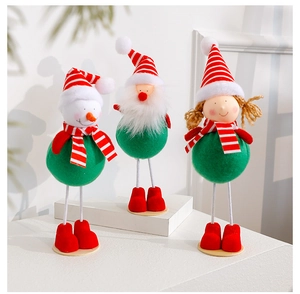 Detailed view of three festive Christmas plush dolls with thin legs on a white base
