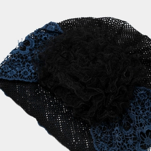 Detailansicht von Turban aus schwarzem Netz mit blauer Spitze und großer geraffter Blume