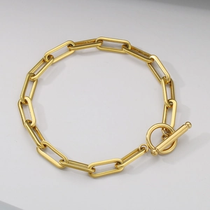 Detail of a minimalist gold paperclip chain bracelet featuring a heart OT toggle closure