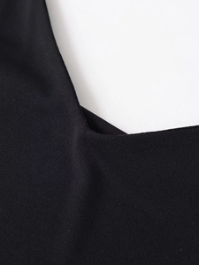 Detail view showing the fine texture and high-quality stitching of the black crepe dress
