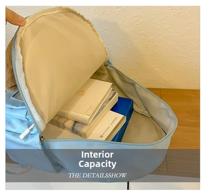 View of the spacious interior compartment of a light blue nylon backpack for kids