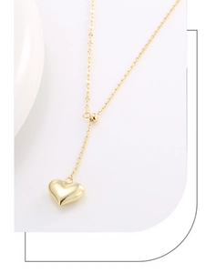 Detail of the 18K gold Y-shaped necklace with polished heart pendant and adjustable slide bead
