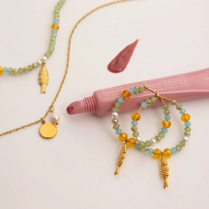 Close-up of 18K gold plated fish pendant with freshwater pearl and multi-color glass beads