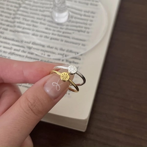 Detailed view of gold and silver stacking rings with engraved sunburst coin charms