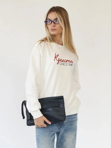 Dettaglio di una felpa in cotone bianco con stampa russa nei colori rosso e nero