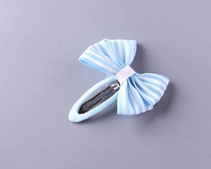 Detailed view of light blue striped bow hair clip for girls made of soft fabric and metal