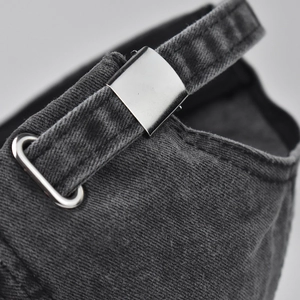 Detail of adjustable metal buckle and vintage washed cotton fabric on the grey baseball cap